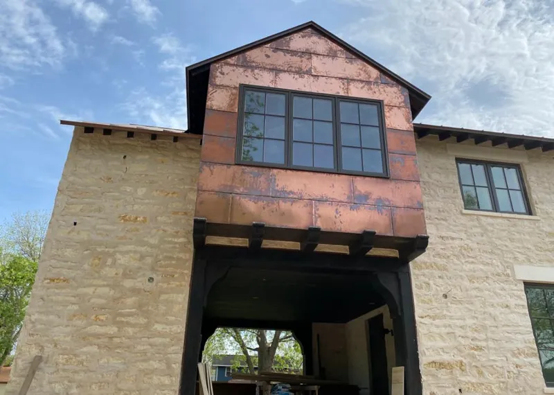 Copper metal panel facade on a stone building for Skylight Installation in Mitchellville